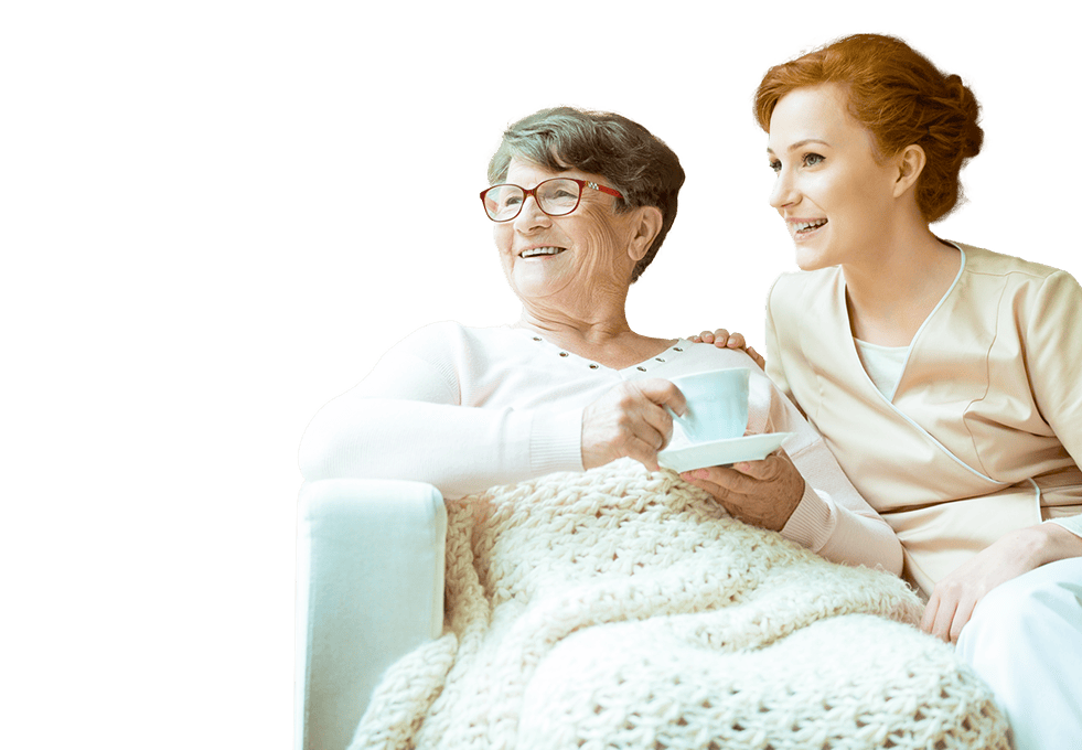 Pflegerin sitzt bei Seniorin welche Tee trinkt